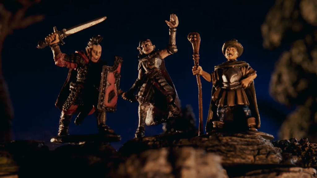 A still image from the documentary Adventure Never Ends: three miniature figurines, adventurers, in a dark scene.